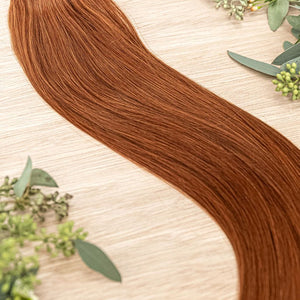 SAFFRON NATURAL TAPE Saffron weft is a 22" piano weft featuring natural-toned level 6 vivid warm copper. Our natural tape hair extensions are carefully crafted to ensure a natural appearance and seamless blending. The hair is placed on the outside of the